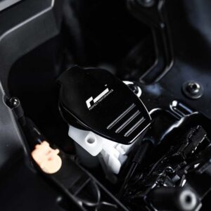 Close-up of a black racing-style car pedal with a cap labeled 'F Perfect Performance' in a dark interior.