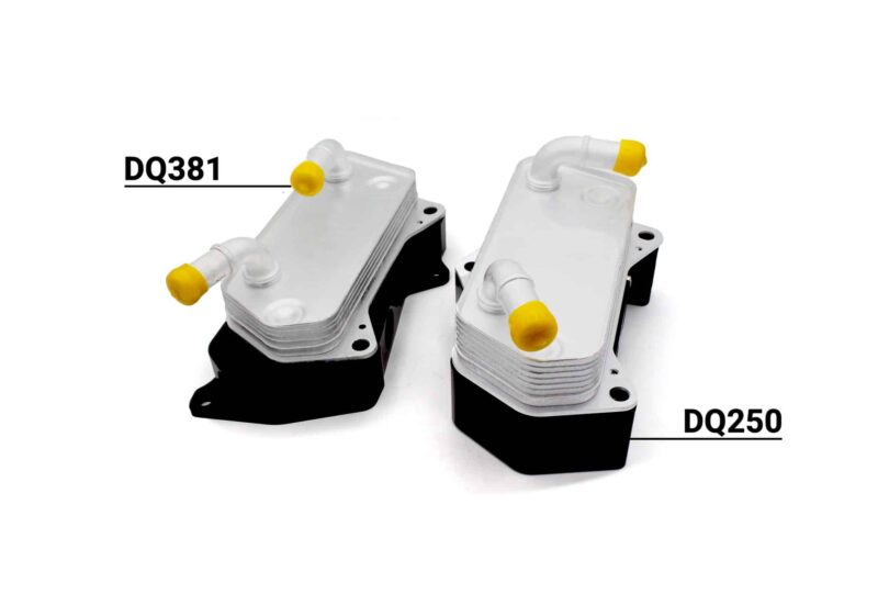 Pair of automotive transmission modules with yellow protective caps and cooling fins, labeled DQ381 and DQ250 as identifiers.
