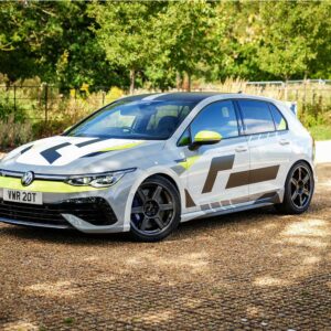 VWR610401_11jpg - OPSHOLDERS White Volkswagen hatchback with lime-green racing livery and bold geometric graphics, parked on gravel with trees in the background