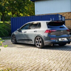 VWR610401_15jpg - OPSHOLDERS SilverVolkswagen Golf GTI hatchback parked in a lot with a blue shipping container and brick building in the background (rear three-quarter view).