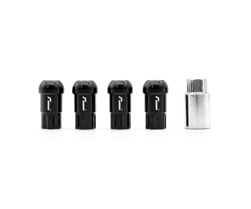 Four black cylindrical components with rounded tops arranged in a row beside a small silver hex tool on a white background, photographed in a studio.