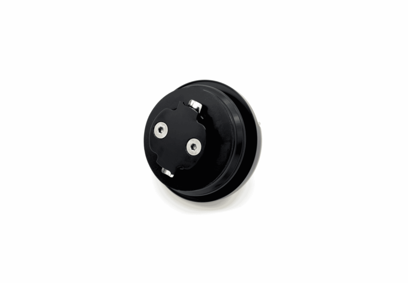 Close-up of a black circular mechanical part with silver screws on a white background.