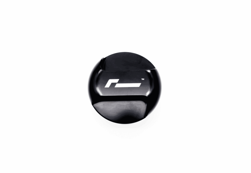 Black glossy circular object with a white geometric logo on a white background, photographed from slightly below.
