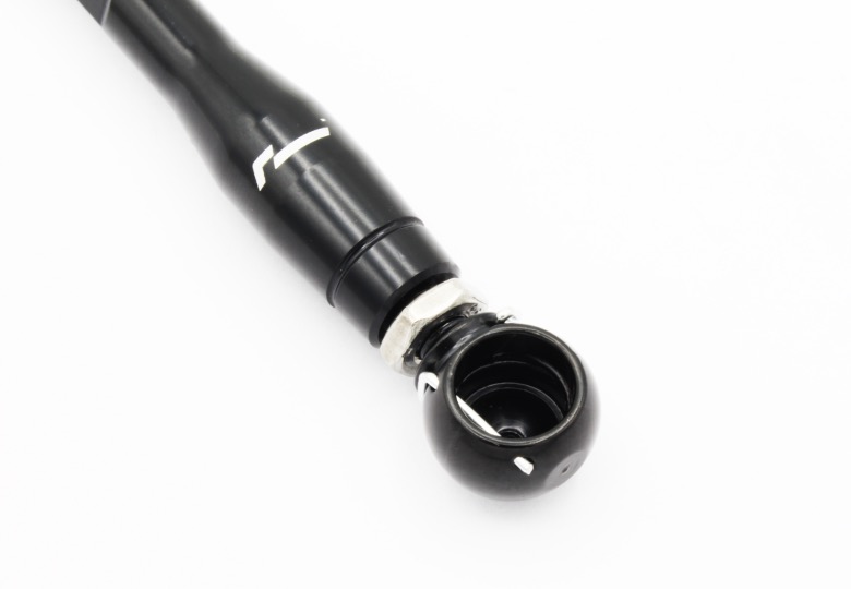 audi-c8-adjustable-height-suspension-links_53337851229_o-1jpg - OPSHOLDERS Close-up of a black bicycle handlebar grip with its end cap removed, showing the inner cavity and metal ring.