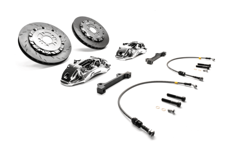 Disassembled high-performance car brake kit with rotors, calipers, lines, brackets and hardware.