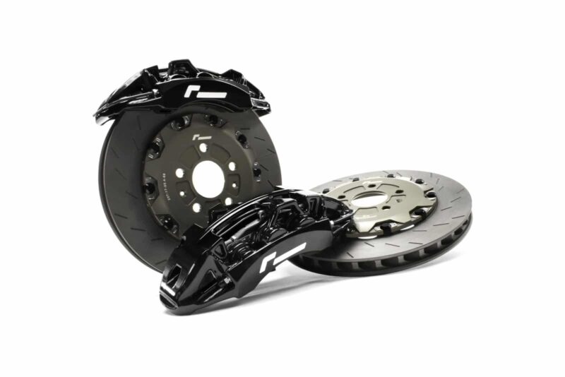 Automotive brake kit with black calipers and ventilated disc rotors on a white background, showing hub in the center.