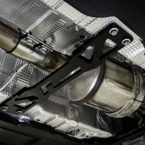Underside of a car showing an exhaust pipe and mounting bracket with silver heat shielding above it