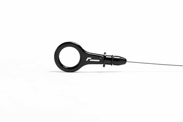 dipstick-1jpg - OPSHOLDERS Black ring-shaped handheld device attached to a thin needle-like wire, shown on a white background.