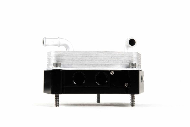 Aluminum hydraulic valve manifold with two top pipe fittings mounted on a black base with bolts.