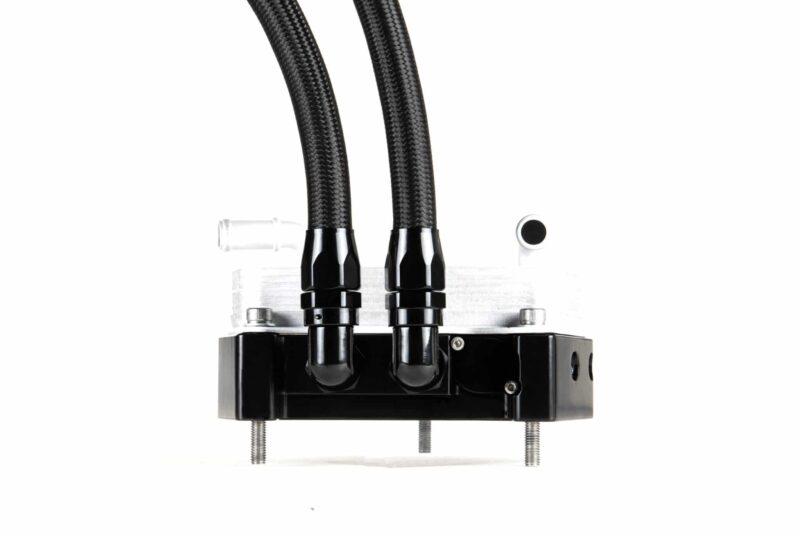 Close-up of two braided hoses with metal connectors mounted on a black industrial base.