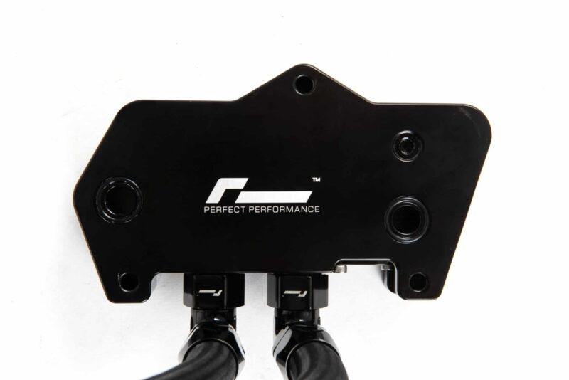dsg-cooler-dq250_49501426127_o-scaled-2jpg - OPSHOLDERS Close-up of a black mounting plate with multiple circular holes and the 'PERFECT PERFORMANCE' logo visible on the surface.