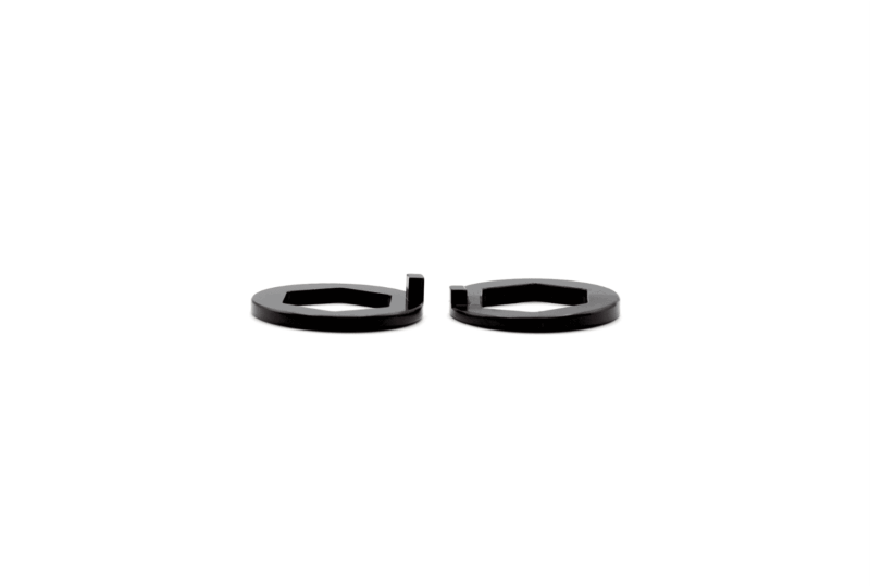 Two black circular spacers with rectangular cutouts, placed side by side on a white background