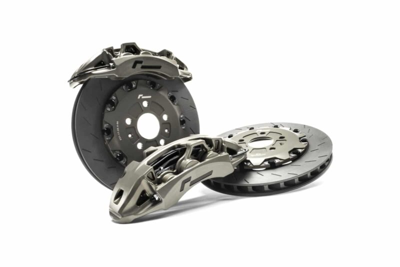 High-performance brake rotors and calipers laid out as a complete brake system set.