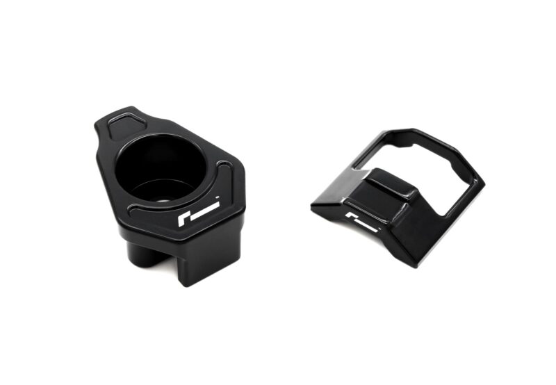 lower-motor-mount-twin-dogbone-inserts_52731172407_o-1jpg - OPSHOLDERS Close-up of two black bicycle pedals, left pedal with a round opening and recessed grip, right pedal with a square cage against a white background