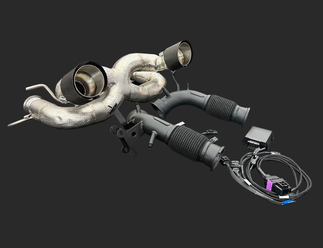 maserati-mc20-2020-exhaust-stage2-seletronjpg - OPSHOLDERS Aftermarket car exhaust header with twin pipes and a wiring harness beside it.
