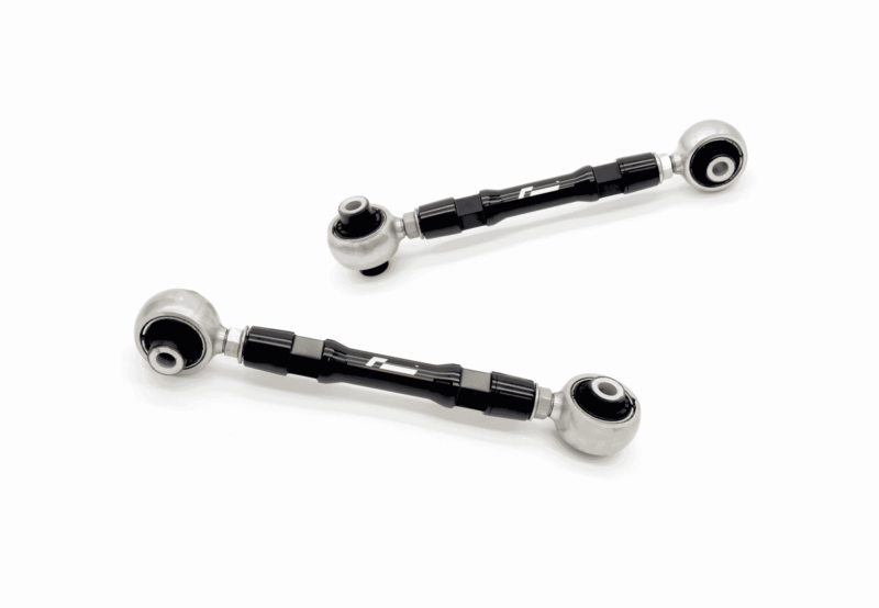 Two black rod-end joints with silver spherical ball joints on a white background, part of a car suspension linkage.