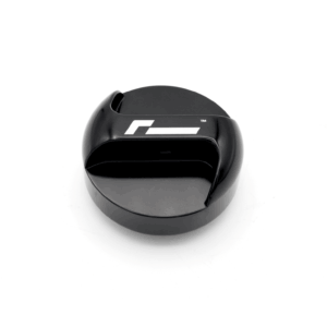 Close-up of a glossy black circular gadget with a white stylized logo on the top surface.
