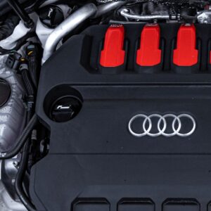 oil-cap-gen4-mqb-evo_51747283825_o-1jpg - OPSHOLDERS Close-up of an Audi engine bay: black engine cover with four red ignition coil covers and the Audi ring logo visible on the front.