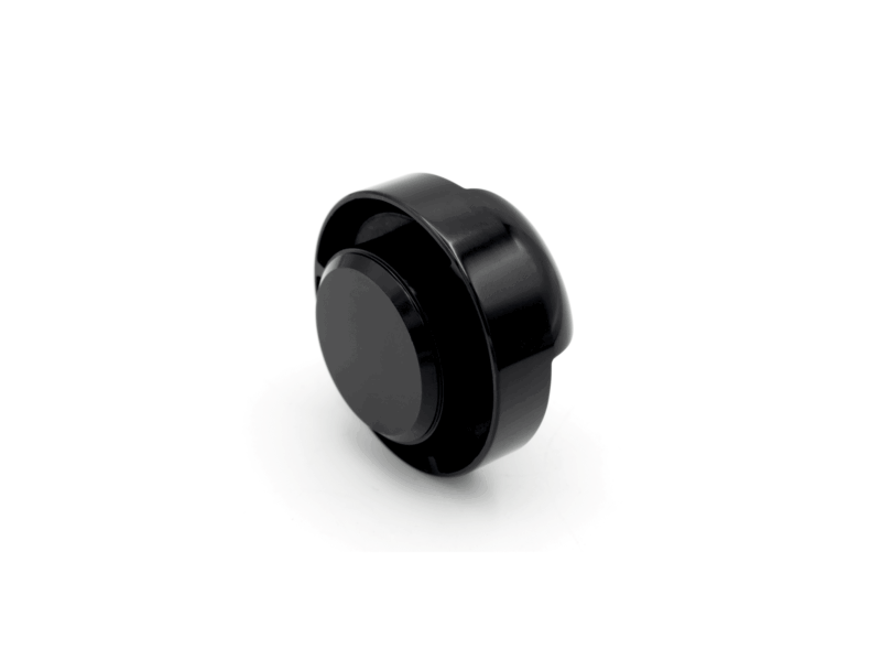 oil-cap-gen4-mqb-evo_51747284005_o-1png - OPSHOLDERS Close-up of a glossy black over-ear headphone ear cup tilted on a white surface