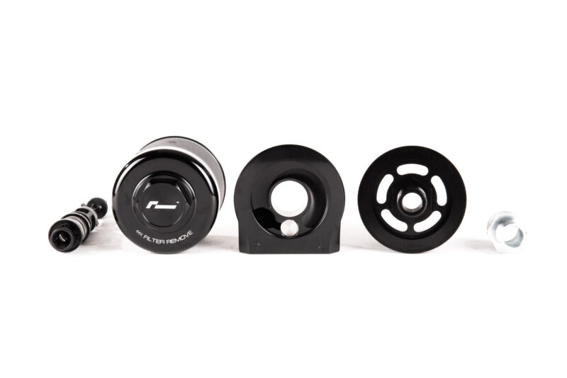 oil-cooler-vwr18-g700_45869746371_o-scaled-1jpg - OPSHOLDERS Assorted bicycle components (pulleys, bearings and hubs) arranged in a row on a white background, showing black metal disks and hardware parts for a derailleur system.