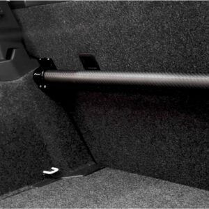 Close-up of a car interior showing a pedal and textured floor mat from the driver’s side.