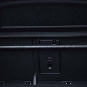 Car trunk area with folded rear seats and a retractable cargo cover across the opening.