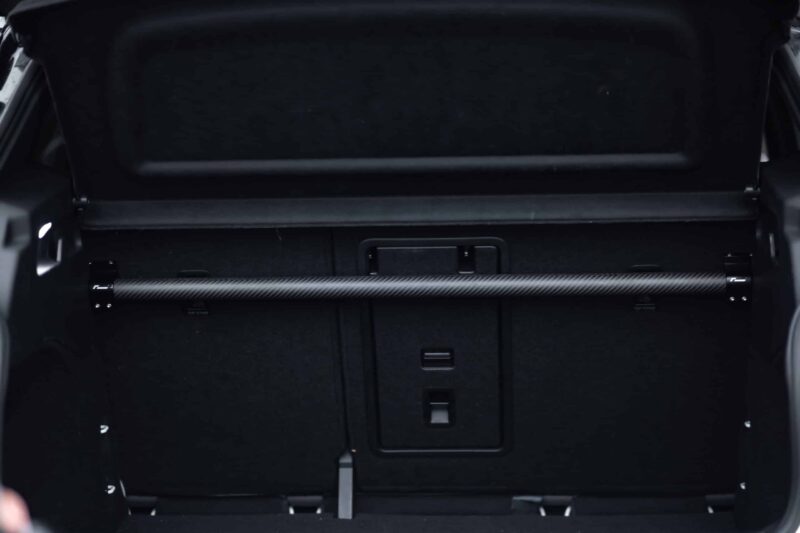 Car trunk area with folded rear seats and a retractable cargo cover across the opening.