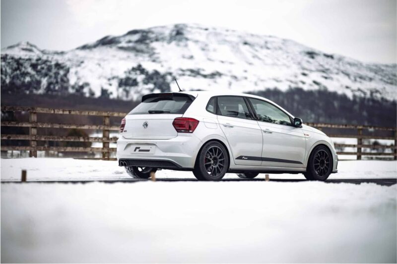 polo-gti-aw-intercooler_53248438794_o-scaled-2jpg - OPSHOLDERS White VW hatchback parked on snow with snow-covered mountains in the background