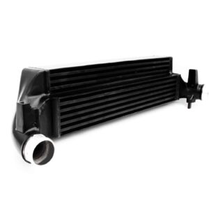 polo-gti-aw-intercooler_53248438864_o-scaled-2jpg - OPSHOLDERS Close-up of a black automotive intercooler/radiator with parallel fins and metal end tanks, viewed from the side angle.