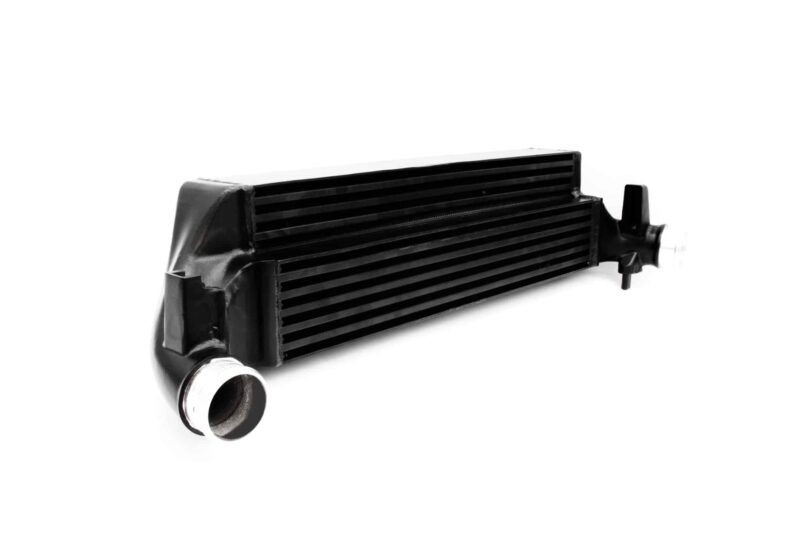 polo-gti-aw-intercooler_53248438864_o-scaled-2jpg - OPSHOLDERS Close-up of a black automotive intercooler/radiator with parallel fins and metal end tanks, viewed from the side angle.