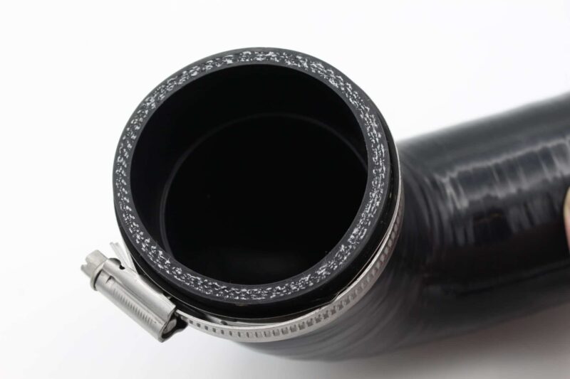 Close-up of a camera lens barrel with a frost-speckled metal ring around the open front element