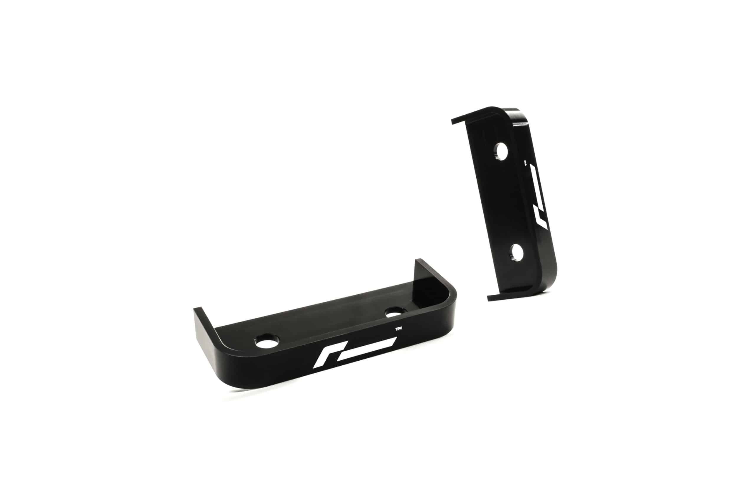 propshaft-bearing-alignment-kit_51768529491_o-scaled-2jpg - OPSHOLDERS Two black metal mounting brackets with circular holes, shown in an angled view against a white background (hardware components).