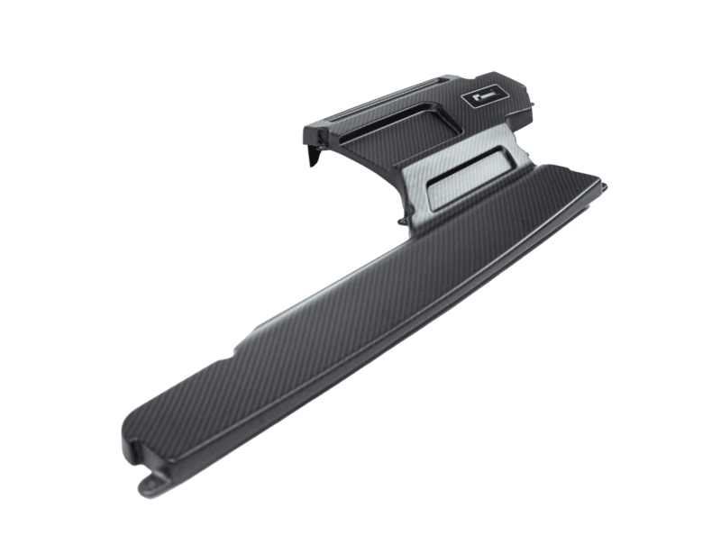 Close-up of a black carbon-fiber bicycle pedal with textured surface and clip-in toe cage, angled diagonally