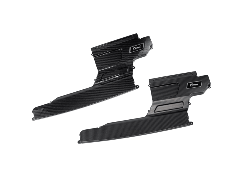 Set of black carbon-fiber automotive body panels angled diagonally on a white background, showing glossy weave and mounting points