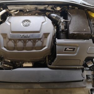 Volkswagen engine bay with a prominent TSI cover and air intake hose on the right side.