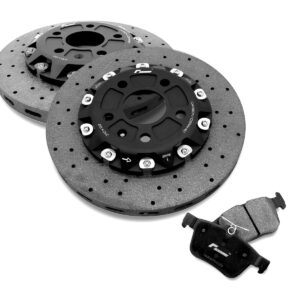 High-performance brake components: drilled rotors with black central hubs and mounting bolts, plus a pair of brake pads on a white background.