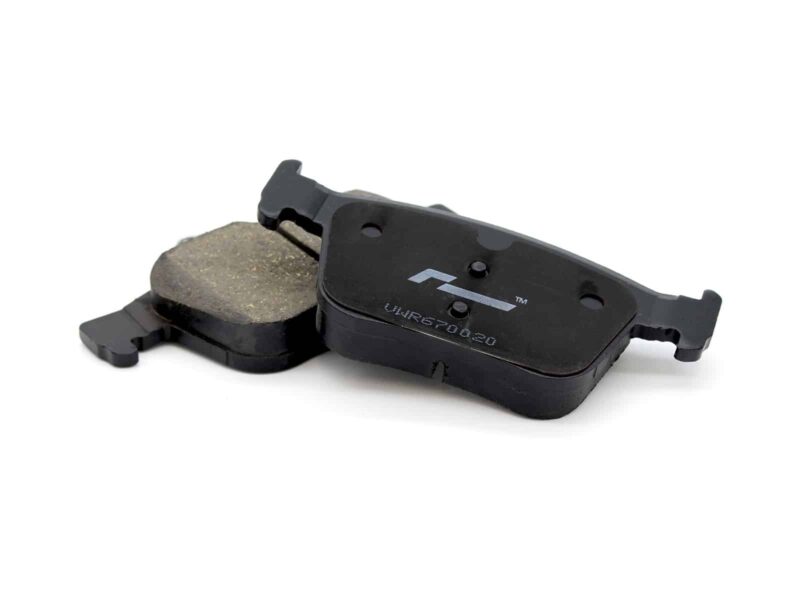 Pair of black disc brake pads with worn friction material on a white background, showing the pads' backing plates on a bicycle brake set