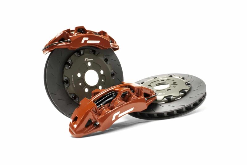 Orange brake calipers over black ventilated brake discs, automotive braking system