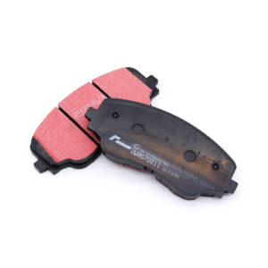 Two red brake pads with black backing plates on a white background, showing wear marks and mounting surfaces for a disc brake system