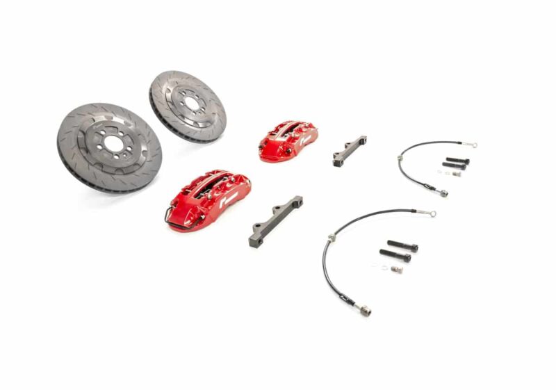 Two ventilated brake rotors, red calipers, mounting brackets, and braided brake lines with fittings laid out.