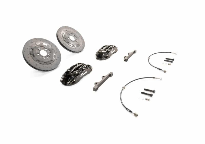 Disassembled motorcycle brake kit with two vented rotors, calipers, pads, brackets, and hydraulic lines on white background.