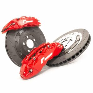 Red high-performance brake calipers mounted on vented brake rotors, isolated on white background.