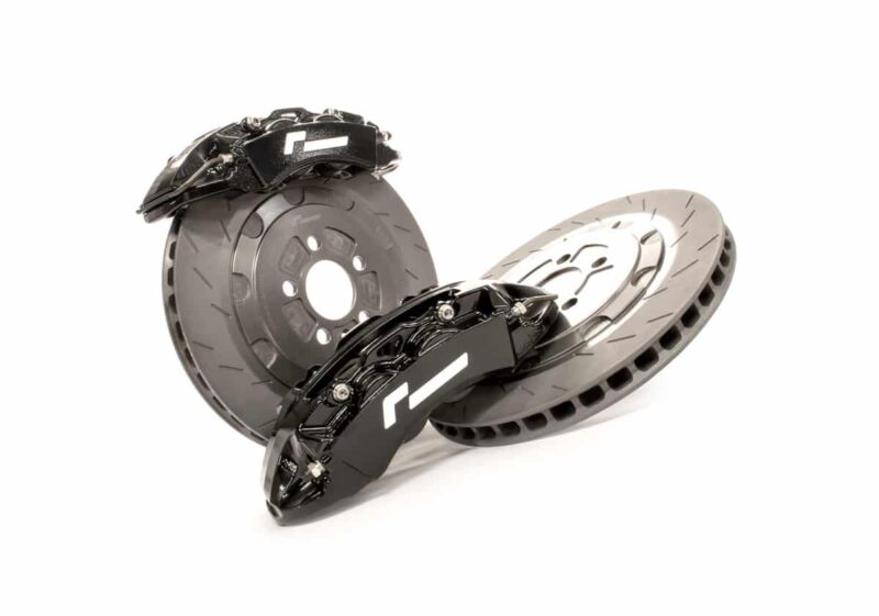 Two ventilated brake discs with black high-performance calipers resting on a white background.