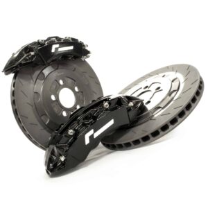 stage-2-evo-brake-kit_51479161930_o-scaled-2jpg - OPSHOLDERS Close-up of a black disc brake caliper mounted on a perforated metal brake rotor against a white background.