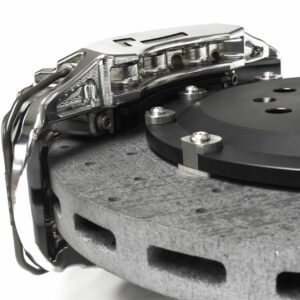 stage-3-ccm-brake-kit_50585982583_o-scaled-2jpg - OPSHOLDERS Close-up of a hard disk drive's read/write head assembly over the spinning platter surface.