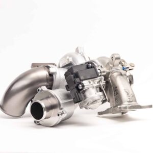 Close-up of a metallic turbocharger component with pipes and a black actuator on a white background