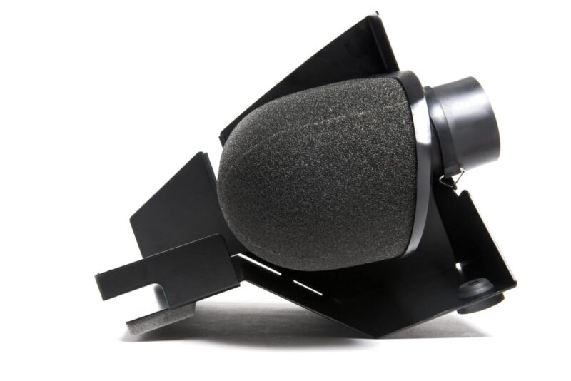 Close-up of a black studio microphone with foam windscreen mounted on a metal stand.