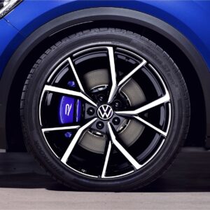 vw-t-roc-r-sport-springs_52959778584_ojpg - OPSHOLDERS Close-up of a blue VW car wheel showing a black and silver alloy rim and blue brake caliper behind the spokes.
