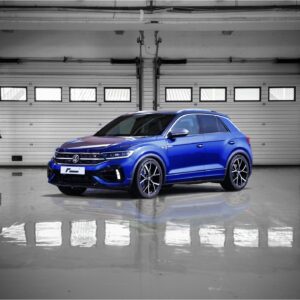 vw-t-roc-r-sport-springs_52960017670_ojpg - OPSHOLDERS Blue SUV parked in a clean, empty garage with metal sectional doors and a glossy floor.