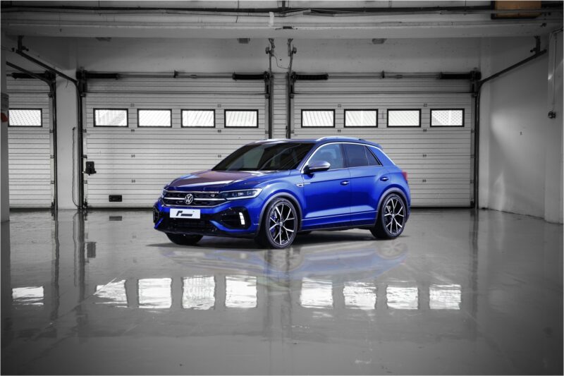 vw-t-roc-r-sport-springs_52960017670_ojpg - OPSHOLDERS Blue SUV parked in a clean, empty garage with metal sectional doors and a glossy floor.